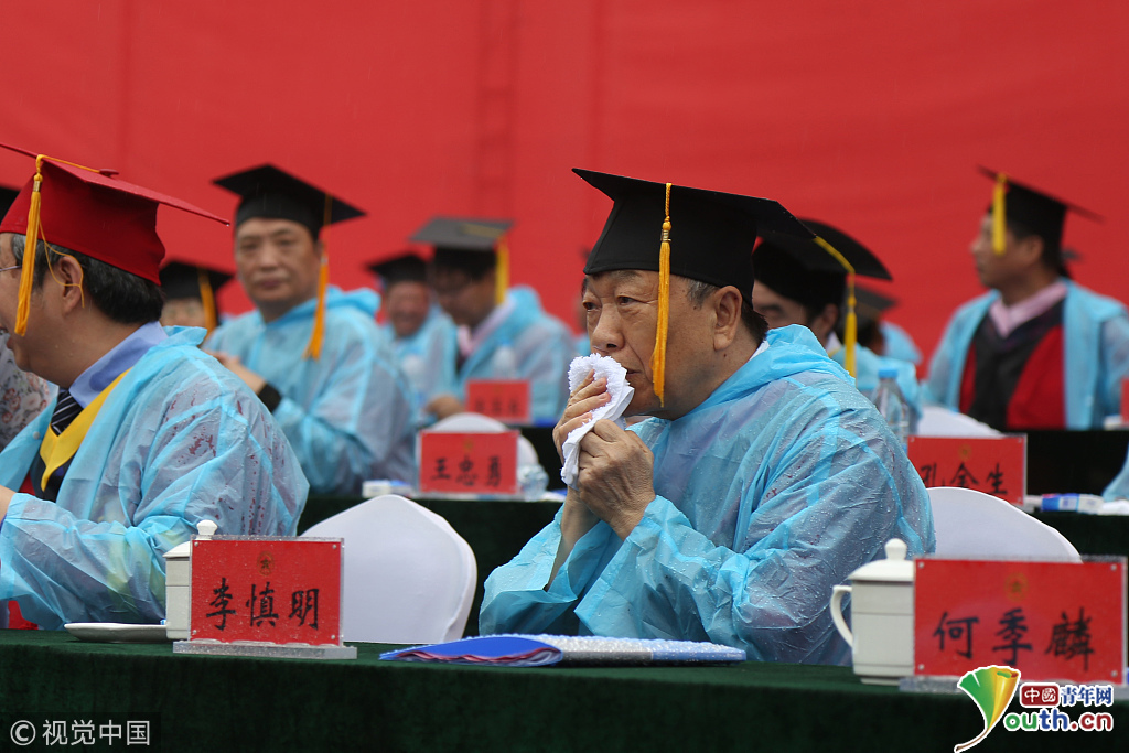郑州大学毕业典礼遇降雨 万余毕业生与教授撑伞穿雨衣