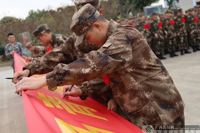 新兵在宣誓横幅上签名.广西新闻网通讯员 廖夏 摄