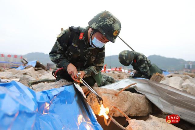武警雅安支队救援官兵利用火焰切割机对"被埋压人员"上方的建筑钢筋