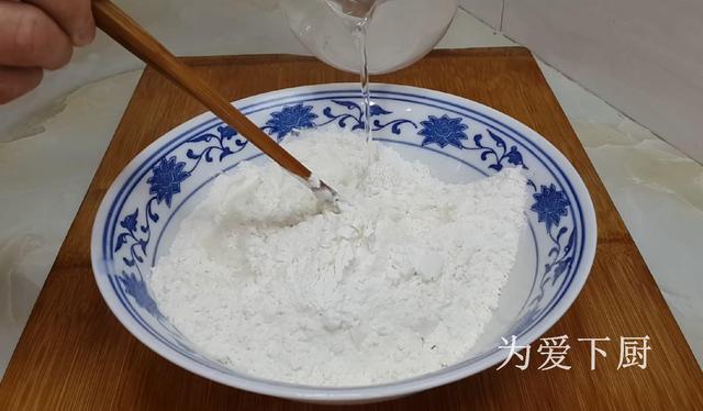 加入300克面粉,4克精盐,倒入80克开水(水温90度别用滚烫开水)