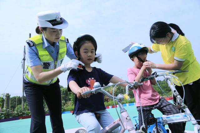 你的育儿经|图｜安徽庐江：“铁骑”“萌娃”共舞“一盔一带”