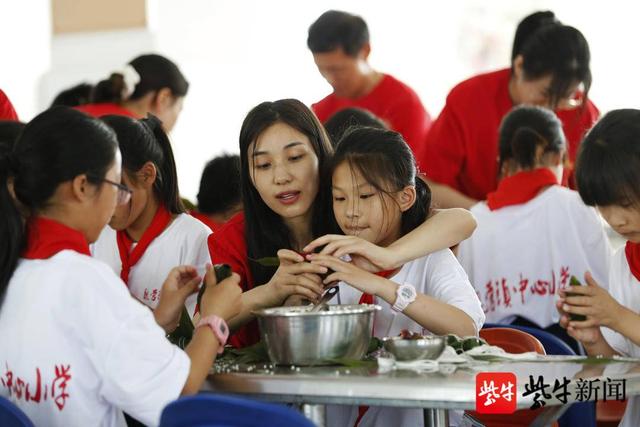 留守的孩子们在老师的指导下学习包粽子