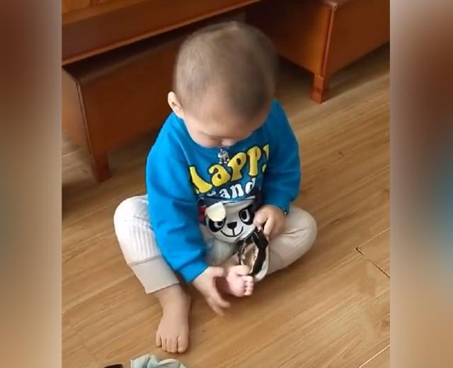 宝宝反拿鞋子穿鞋怎么也穿不上，跟妈妈告状说脚不听话，太可爱了