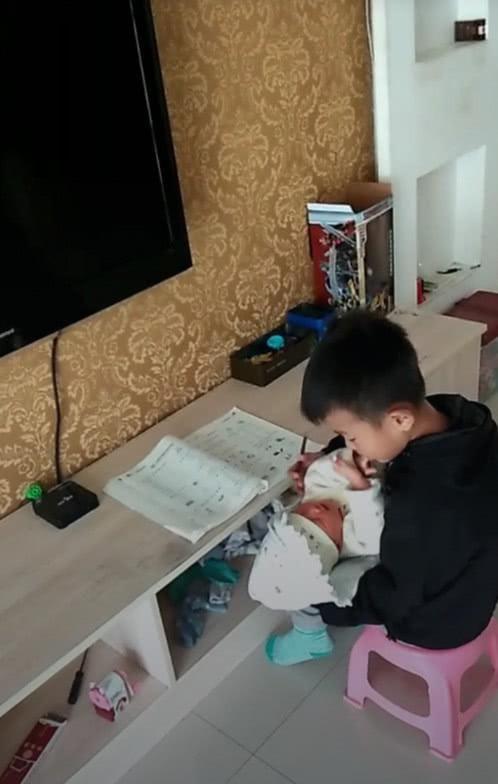 儿子心疼妈妈，一边写作业一边哄妹妹，网友：姐姐等你20年！
