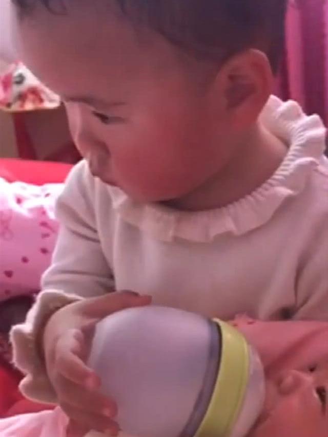 一岁半姐姐给弟弟喂奶，无奈的深深叹了口气，妈妈一旁忍不住笑了
