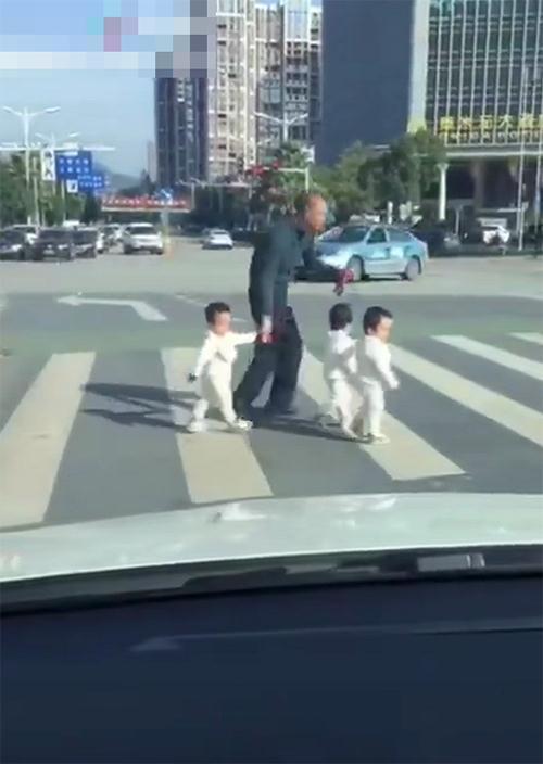 爸爸带三胞胎过马路，眼看马上变红灯，爸爸低头弯腰一抄，笑喷了