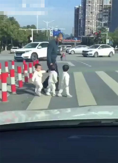 爸爸带三胞胎过马路，眼看马上变红灯，爸爸低头弯腰一抄，笑喷了