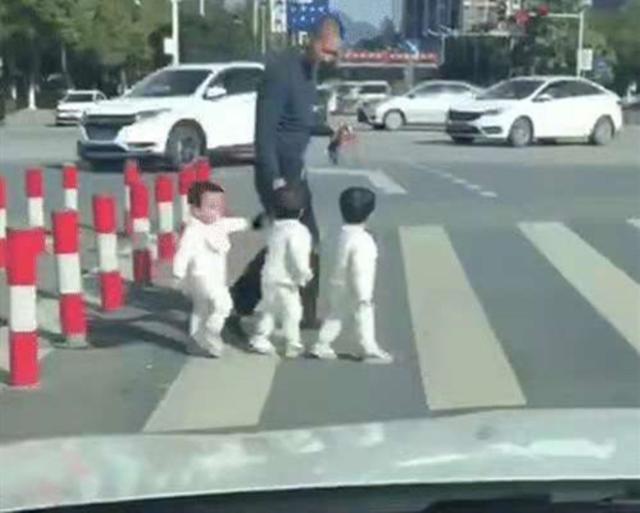 爸爸带三胞胎过马路，接下来的动作，网友：确定不是拐小孩的吗？