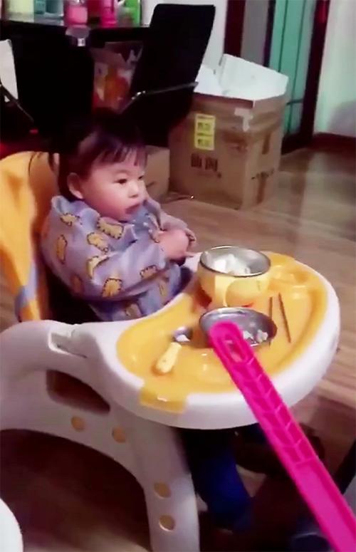 宝宝吃饭不认真，妈妈拿着苍蝇拍走过去，宝宝回头瞅见后，笑喷了