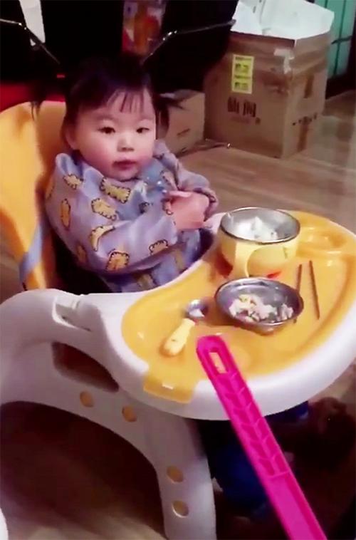 宝宝吃饭不认真，妈妈拿着苍蝇拍走过去，宝宝回头瞅见后，笑喷了