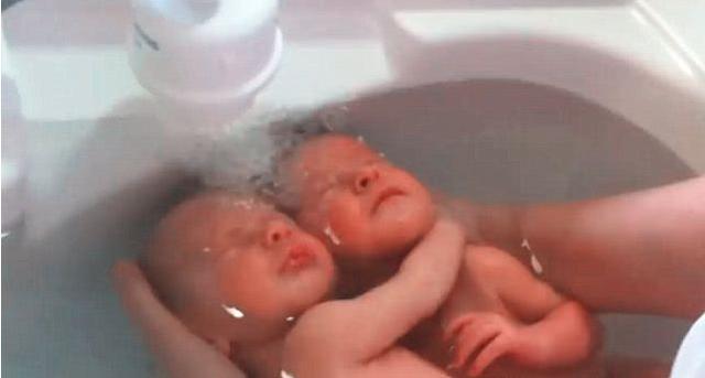 护士给刚出生的双胞胎宝宝洗澡，放进水里后，宝宝的反应萌化人心