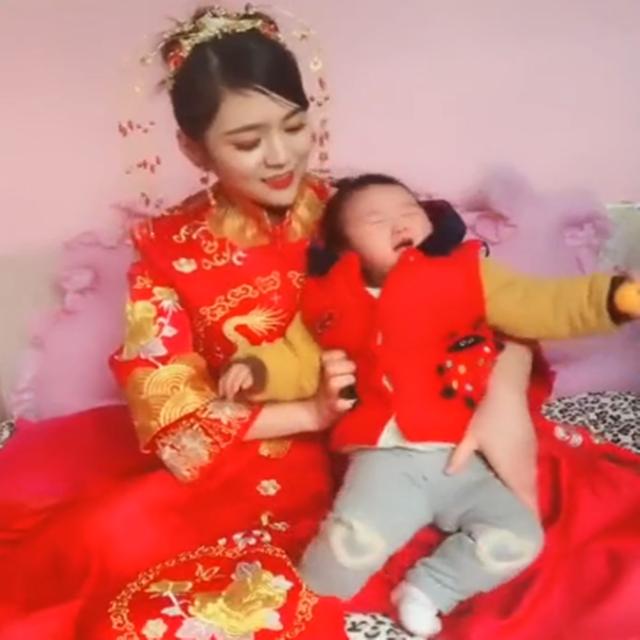 新娘带着一岁多的女儿一起出嫁，女儿一直哭闹，场面有些尴尬