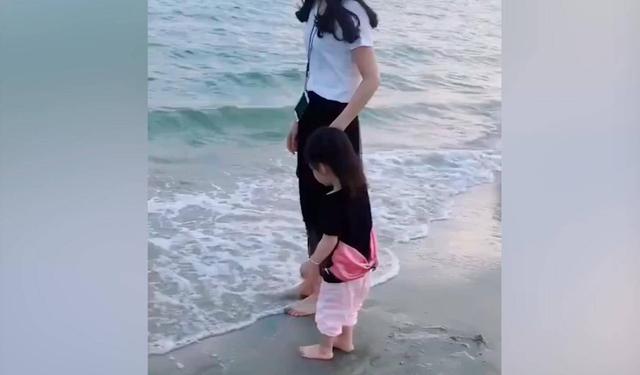 带着女儿去看海，海水飘来的一瞬间，女儿害怕的反应真是萌翻了