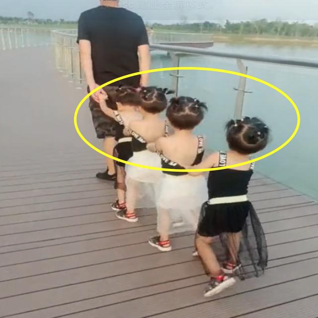 爸爸带四胞胎出去游玩，女儿们的表现太可爱了，让路人羡慕不已