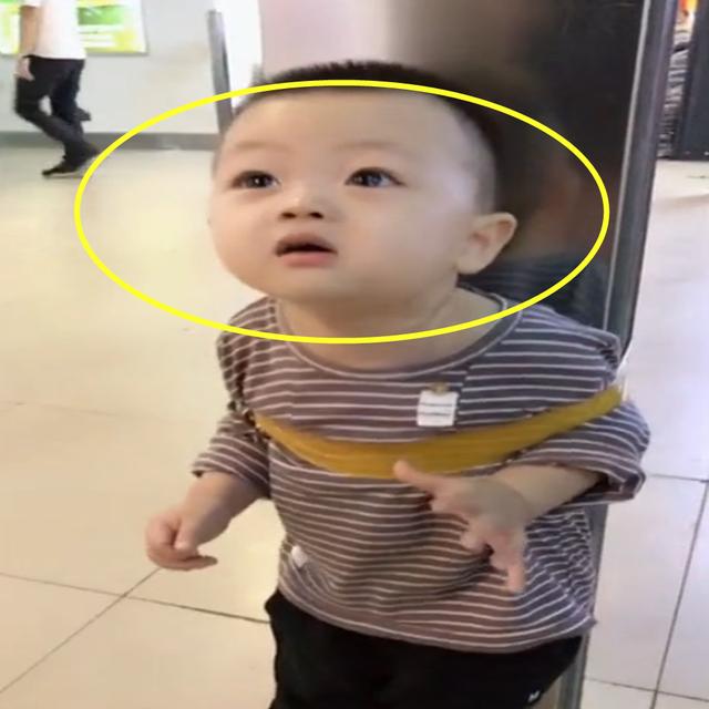 宝宝被绑在柱子上，一脸无奈表情，网友：旁边人的态度让人无语