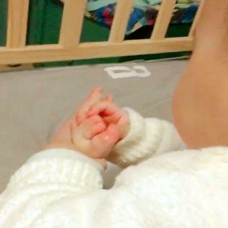 宝宝安安静静坐在小床里，妈妈走过去一看，被宝宝的样子给萌翻了