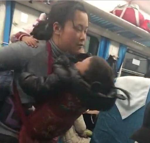 “艰辛妈妈”带两孩子坐火车，背一个抱一个，网友：真是为母则强