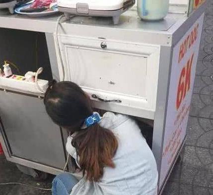 年轻母亲带着7个月大的婴儿卖早餐，并将孩子放在餐车柜里引热议