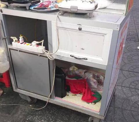 年轻母亲带着7个月大的婴儿卖早餐，并将孩子放在餐车柜里引热议