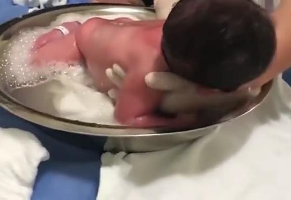 护士给小宝宝洗澡，小家伙享受的样子太可爱，一旁的妈妈笑坏了