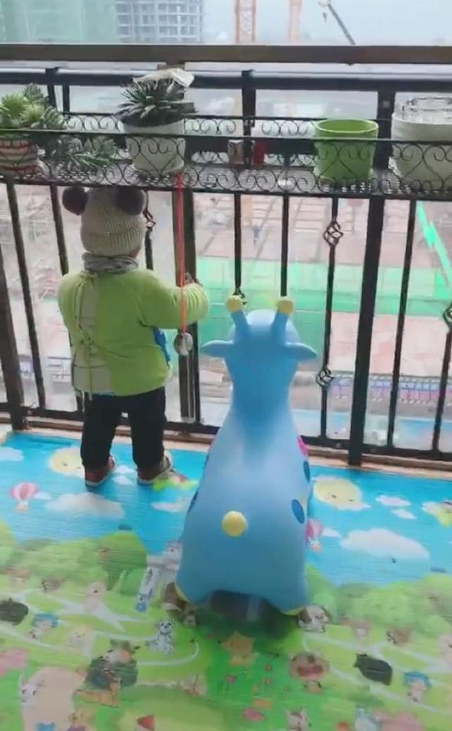 宝宝站在阳台一动不动，妈妈走近一看，被逗得笑哭了