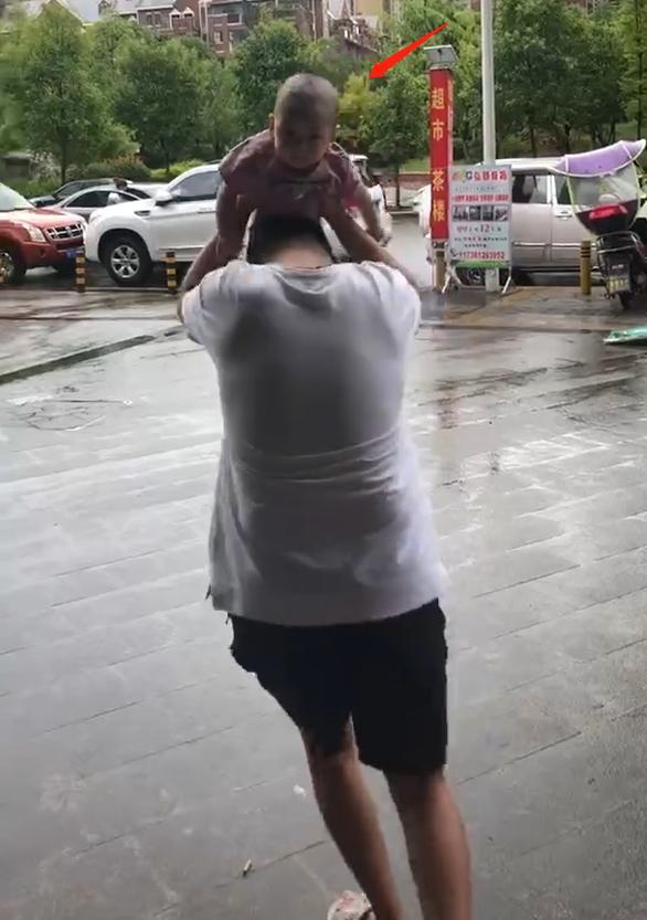 带宝宝出门遇上下雨，爸爸举起宝宝当雨伞，网友：父爱如山体滑坡