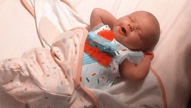 爸爸妈妈早晨叫婴儿起床，解开抱被后，宝宝的反应萌的心都化了