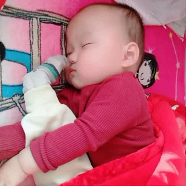 妈妈给爸爸拍照，宝宝边睡觉边压腿，爸爸回家掀被子一看