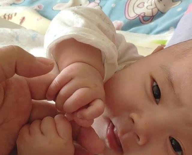 宝宝强拽着宝妈手不放，还深情地看着妈妈！网友：宝宝一定是饿了
