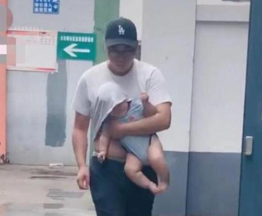 老爸带娃躲雨照一夜走红，只是怀里儿子的表情，有点无奈啊