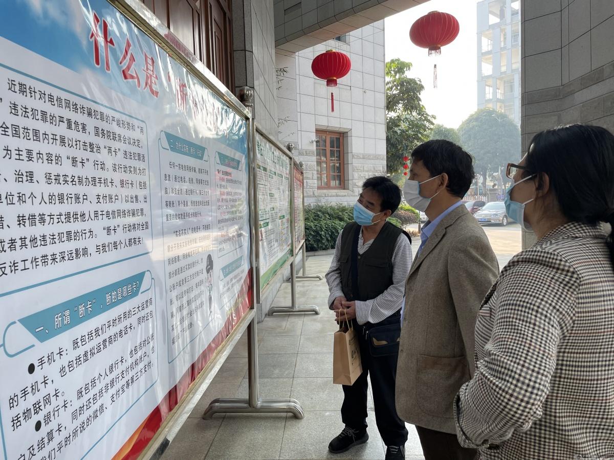 图为客户正在通过该行制作的专题展板了解"断卡"行动.