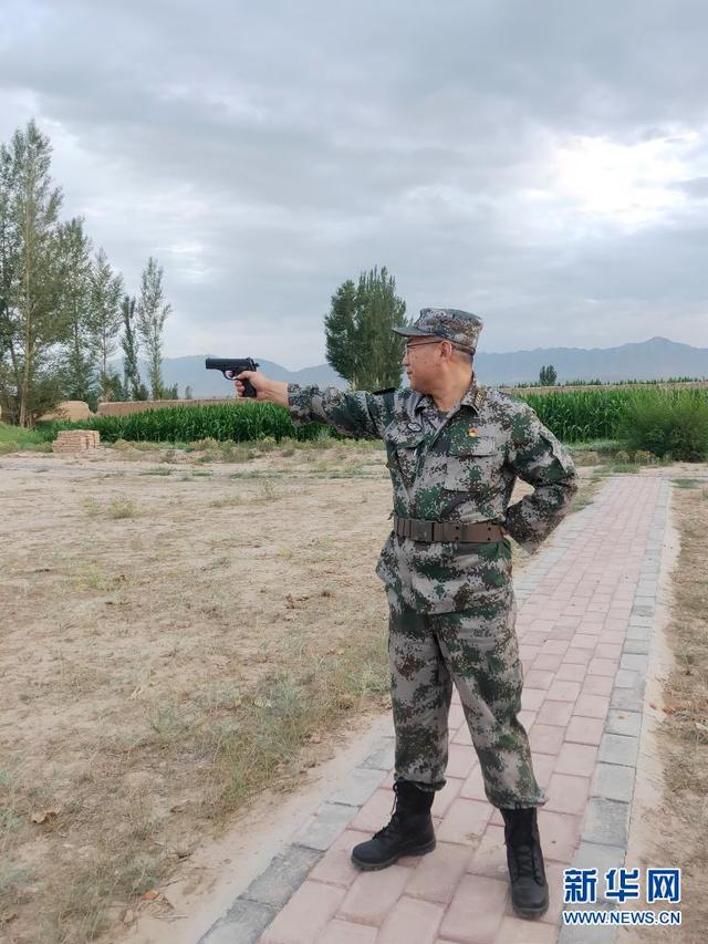 张洪峰右手据枪左眼瞄准进行手枪射击(手机拍摄,2021年7月14日摄).