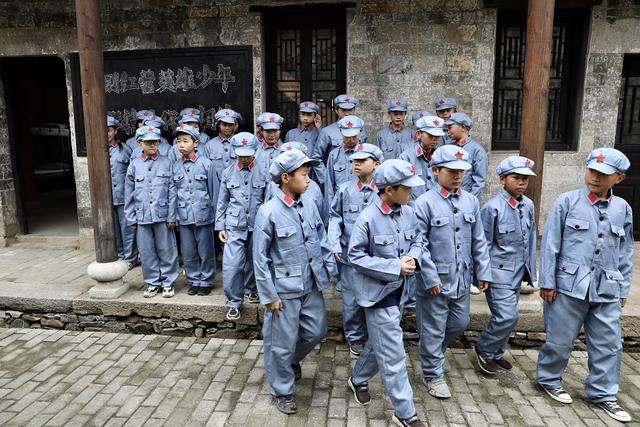 4月23日,穿着红军服的小学生参观鄂豫皖苏区列宁高级学校旧址.