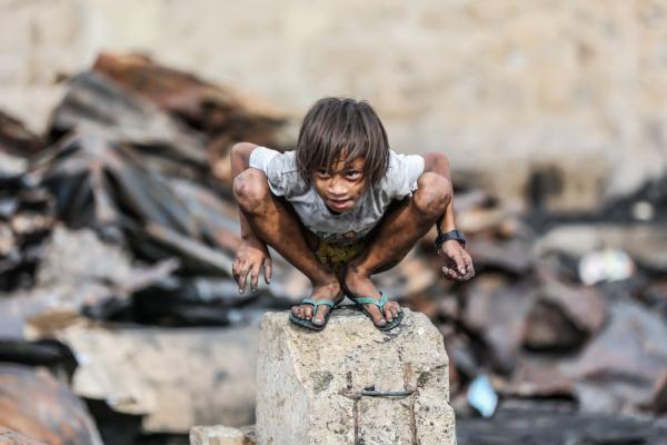5月20日,一名儿童在菲律宾帕西格市发生火灾的一处贫民区内寻找可用