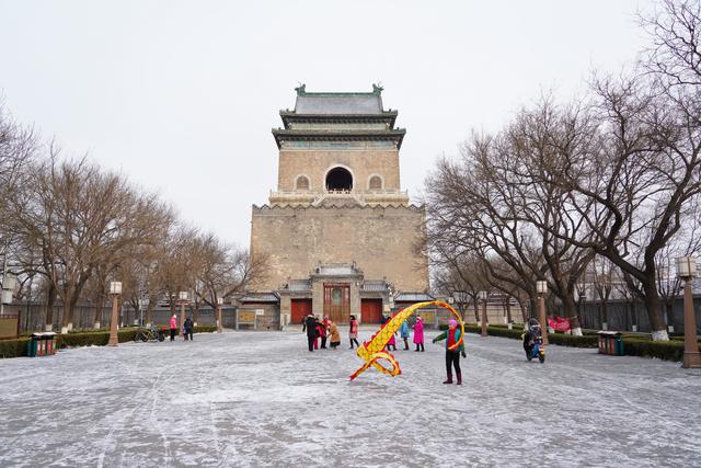 1月19日,在北京钟鼓楼文化广场,市民在雪中休闲运动