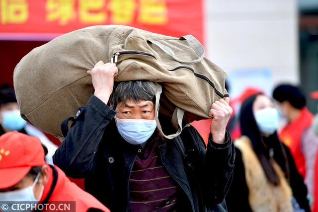 2021年1月28日,旅客带着行李走出安徽亳州火车站.